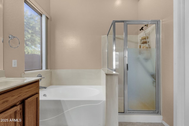 bathroom with vanity and shower with separate bathtub