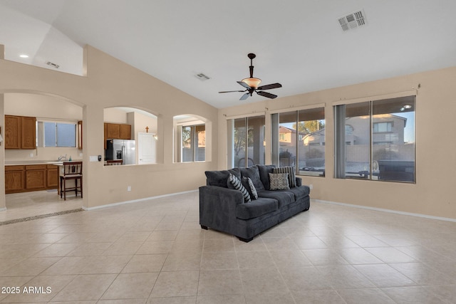 living room featuring lofted ceiling, light tile patterned floors, and ceiling fan