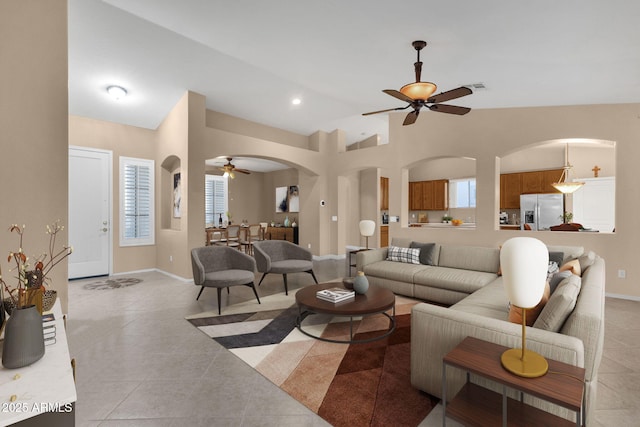 tiled living room featuring ceiling fan and vaulted ceiling