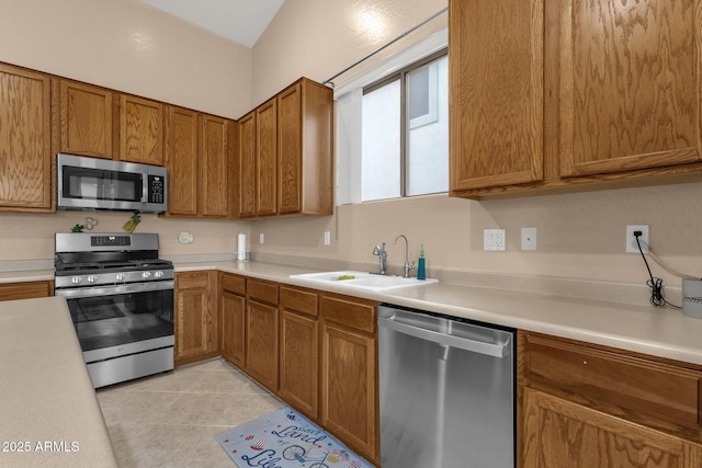 kitchen with stainless steel appliances, sink, and light tile patterned floors