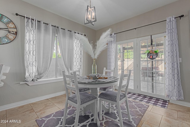 dining area with a chandelier and tile patterned floors