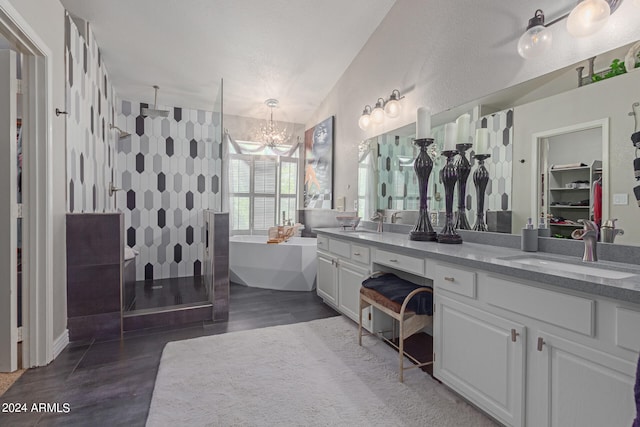 bathroom with plus walk in shower, wood-type flooring, a notable chandelier, lofted ceiling, and vanity