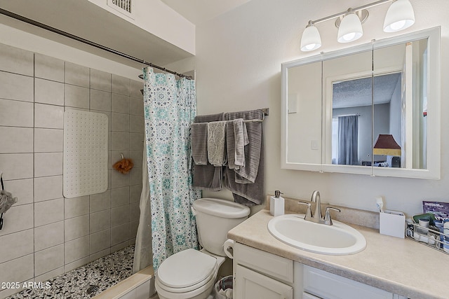 full bathroom featuring vanity, a stall shower, and toilet