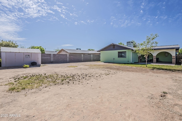 fenced backyard with an outdoor structure, central AC unit, and a patio