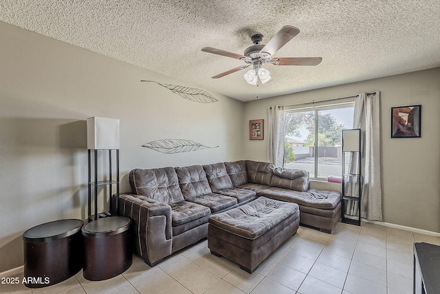 living area with ceiling fan, a textured ceiling, light tile patterned floors, and baseboards