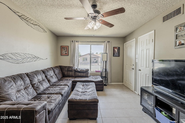 living room with a ceiling fan, a textured ceiling, and light tile patterned floors