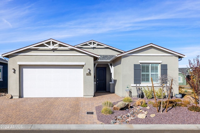 single story home featuring stucco siding, an attached garage, and decorative driveway