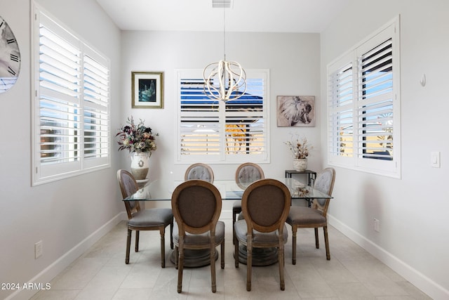 dining room featuring a chandelier, baseboards, and light tile patterned flooring
