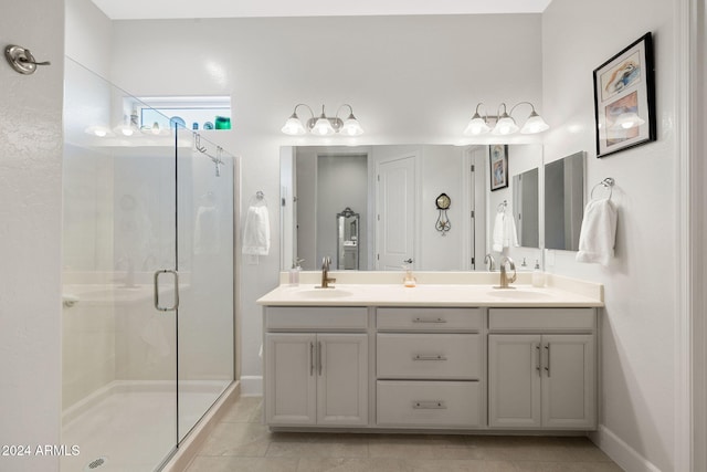 full bath with a sink, double vanity, a shower stall, and tile patterned floors