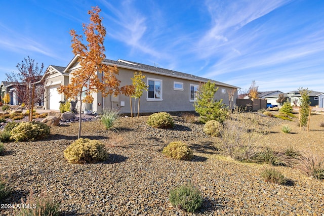 view of property exterior with stucco siding, a residential view, and a garage