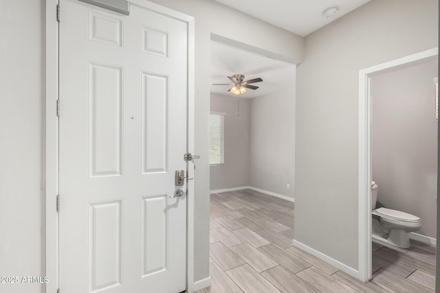 entryway with wood finish floors, baseboards, and ceiling fan