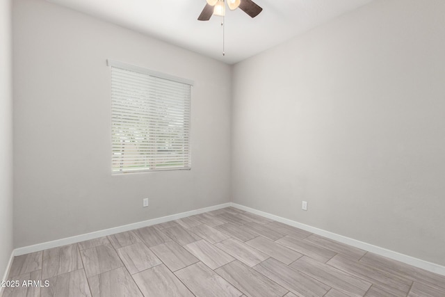 spare room featuring baseboards and a ceiling fan