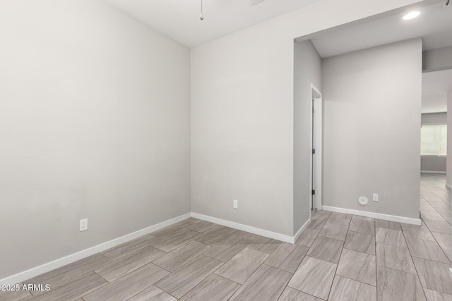 spare room featuring baseboards and wood finish floors