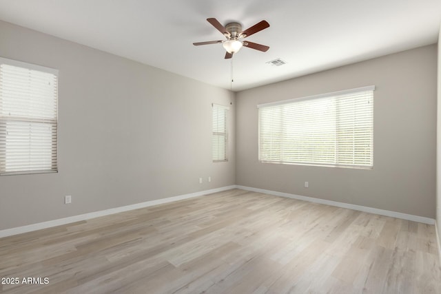 spare room featuring visible vents, light wood-style floors, and a ceiling fan