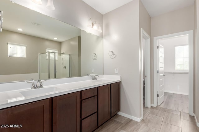 bathroom with plenty of natural light, a shower stall, and a sink