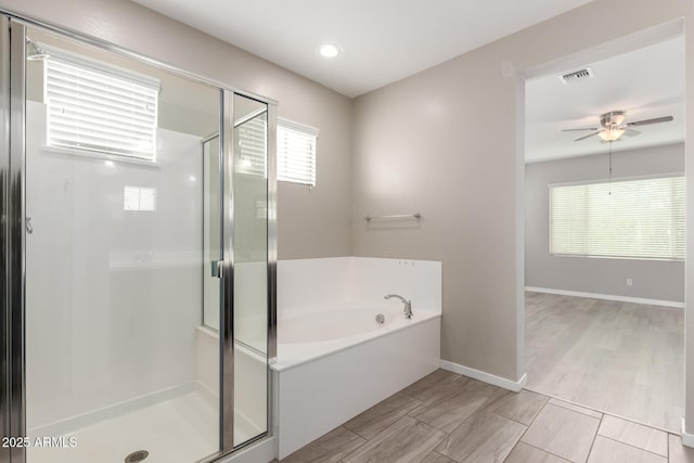 bathroom with wood finished floors, a ceiling fan, visible vents, a stall shower, and a bath