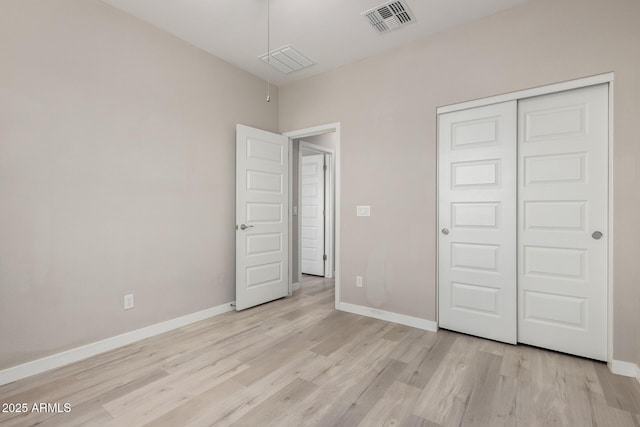 unfurnished bedroom featuring light wood finished floors, visible vents, and baseboards