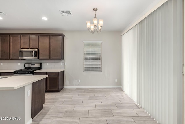 kitchen featuring visible vents, backsplash, stainless steel appliances, dark brown cabinetry, and light countertops