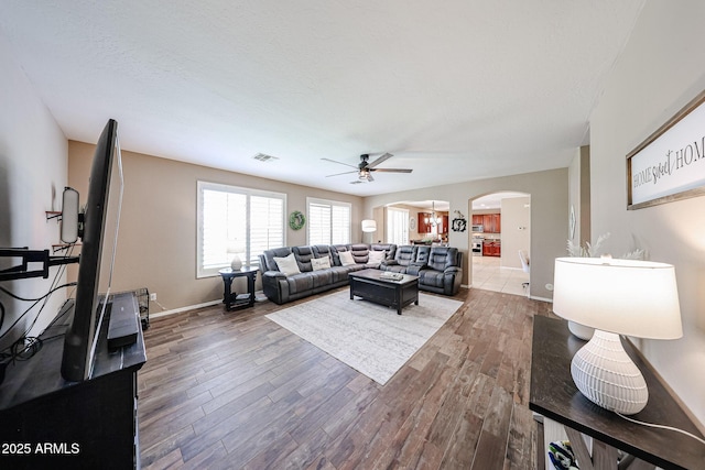 2886 E Hazeltine Way, Chandler, AZ 85249 - living area with visible vents, wood finished floors, baseboards, arched walkways, and a ceiling fan