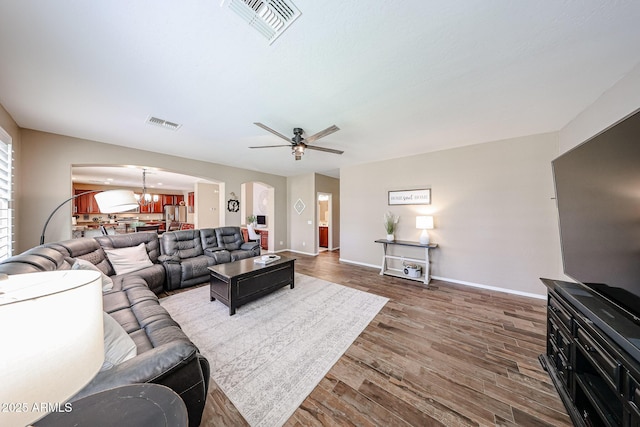 2886 E Hazeltine Way, Chandler, AZ 85249 - living area featuring arched walkways, visible vents, dark wood-style floors, and ceiling fan with notable chandelier