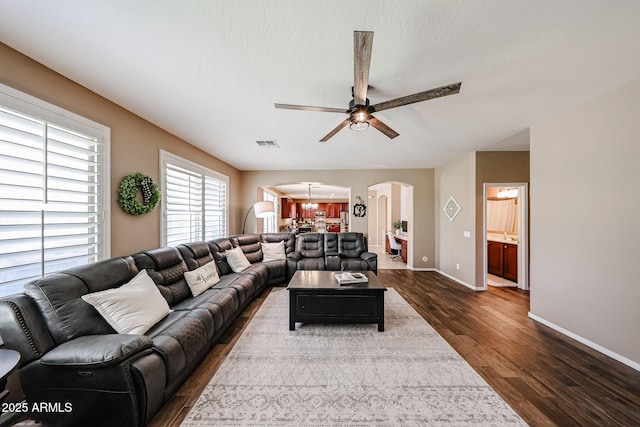 2886 E Hazeltine Way, Chandler, AZ 85249 - living room with visible vents, arched walkways, dark wood finished floors, baseboards, and ceiling fan with notable chandelier