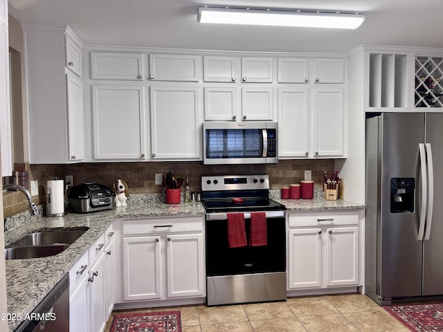 6049 S Wilson Dr, Chandler, AZ 85249 - kitchen with appliances with stainless steel finishes, a sink, white cabinets, light tile patterned floors, and tasteful backsplash
