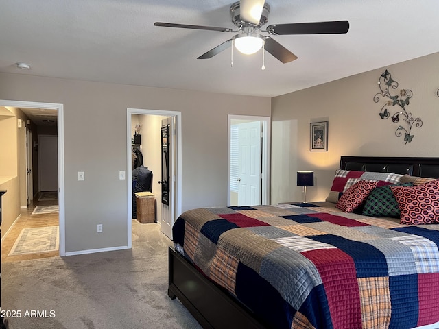 6049 S Wilson Dr, Chandler, AZ 85249 - bedroom with light carpet, a walk in closet, a closet, ceiling fan, and baseboards