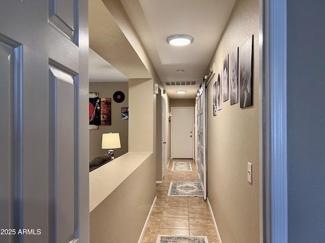 6049 S Wilson Dr, Chandler, AZ 85249 - hallway featuring light tile patterned flooring, a textured wall, and baseboards