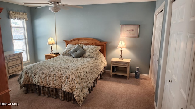 carpeted bedroom with ceiling fan and multiple closets