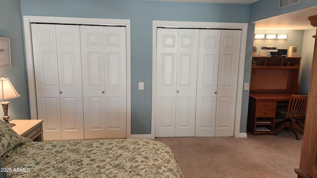 bedroom with carpet floors and multiple closets