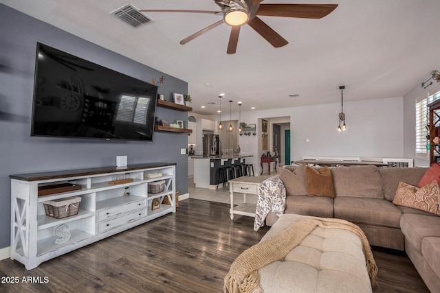 living room featuring ceiling fan and dark hardwood / wood-style floors