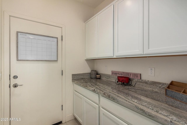 interior space featuring light stone countertops and white cabinetry