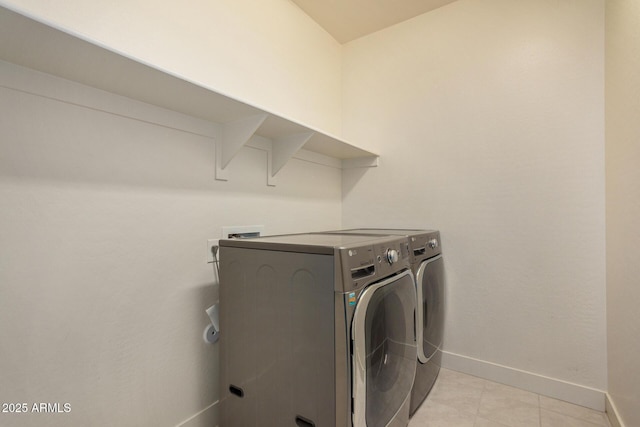 clothes washing area with washer and dryer and light tile patterned floors