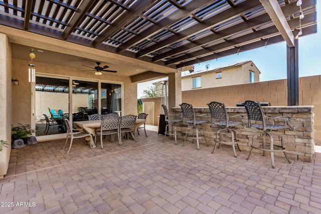 view of patio / terrace featuring a bar, ceiling fan, and a pergola