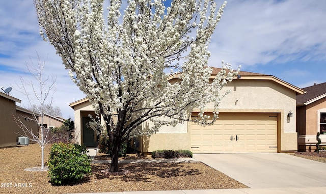 obstructed view of property with driveway, stucco siding, a garage, and central AC
