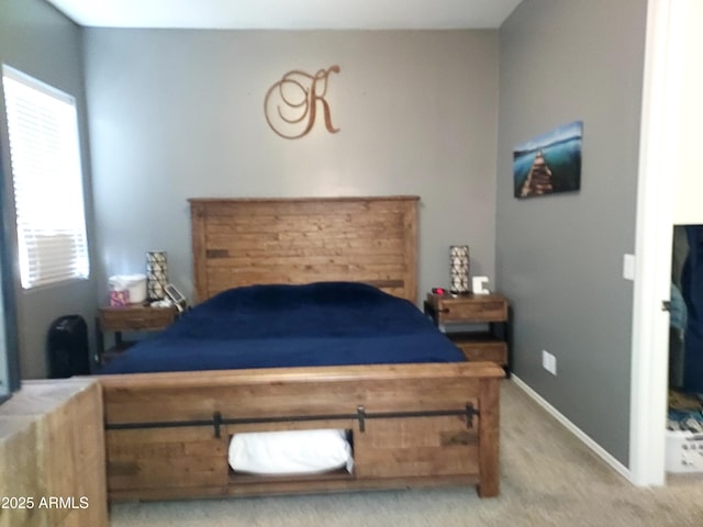 bedroom with baseboards and light colored carpet