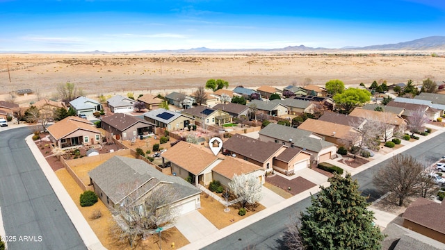 birds eye view of property with a residential view, a mountain view, and view of desert