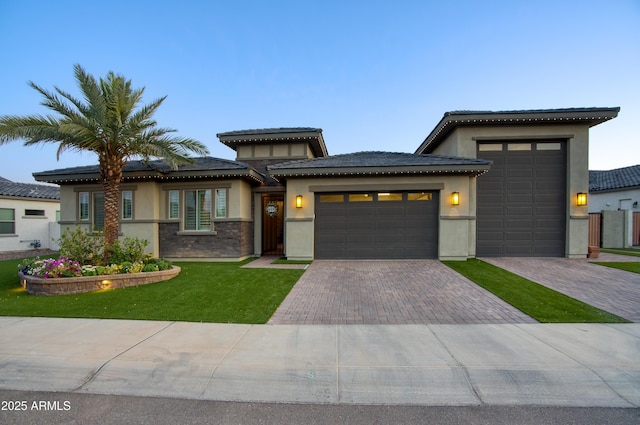 18175 W Highland Ave, Goodyear, AZ 85395 - prairie-style home featuring a garage, stucco siding, driveway, and a front lawn