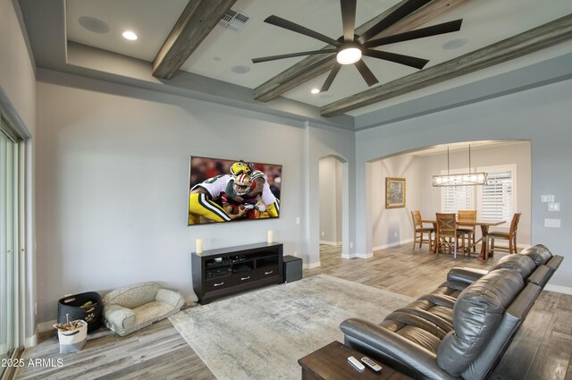 18175 W Highland Ave, Goodyear, AZ 85395 - living area featuring arched walkways, beam ceiling, and wood finished floors