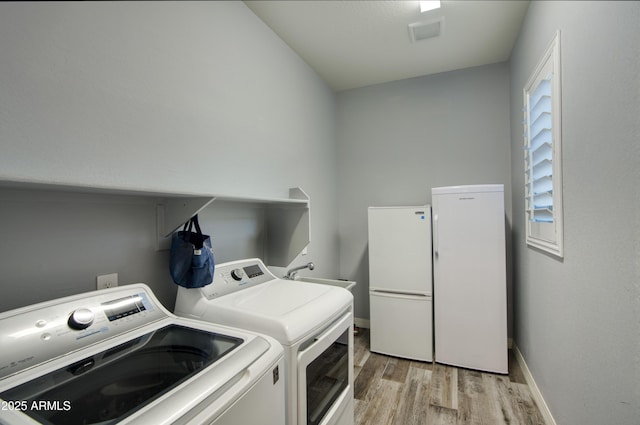 18175 W Highland Ave, Goodyear, AZ 85395 - clothes washing area featuring laundry area, visible vents, baseboards, light wood-style flooring, and washer and dryer