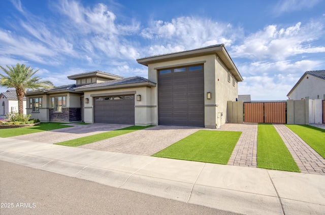 18175 W Highland Ave, Goodyear, AZ 85395 - view of front of property featuring a garage, fence, stucco siding, a gate, and driveway