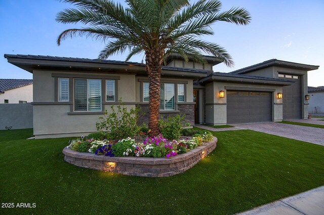 18175 W Highland Ave, Goodyear, AZ 85395 - view of front of home with decorative driveway, a garage, a front lawn, and stucco siding
