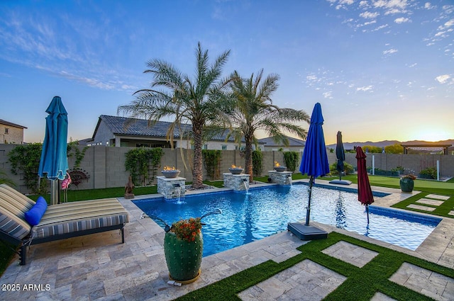 18175 W Highland Ave, Goodyear, AZ 85395 - pool at dusk featuring a fenced in pool, a fenced backyard, and a patio area