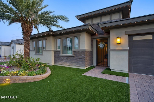 18175 W Highland Ave, Goodyear, AZ 85395 - view of front of house featuring stucco siding, a front yard, and stone siding