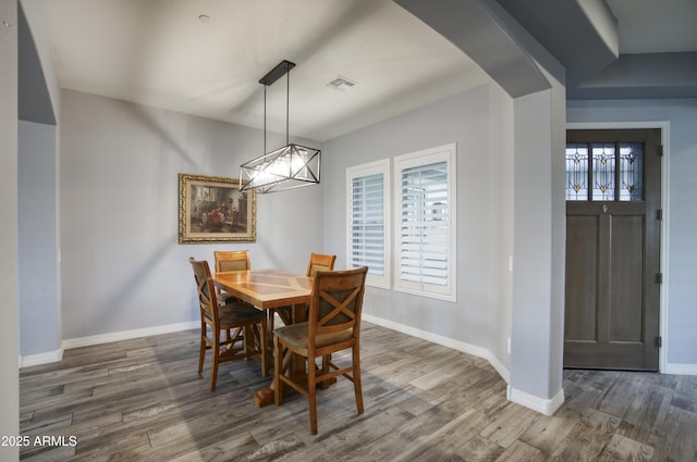 18175 W Highland Ave, Goodyear, AZ 85395 - dining space with baseboards, arched walkways, wood finished floors, and visible vents