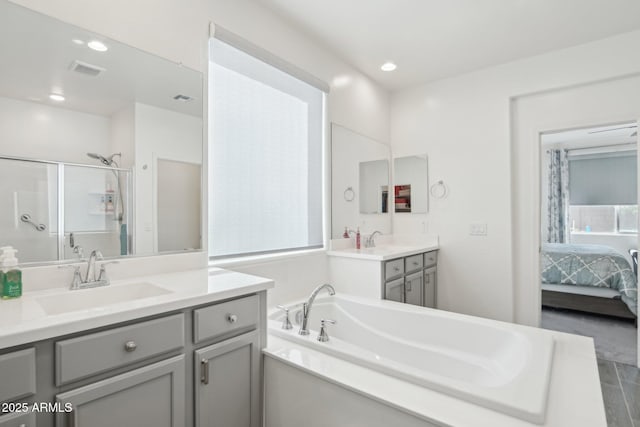 full bath featuring a sink, visible vents, two vanities, and connected bathroom