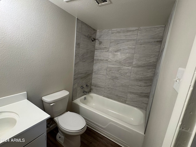 full bathroom featuring tiled shower / bath, vanity, wood-type flooring, a textured ceiling, and toilet