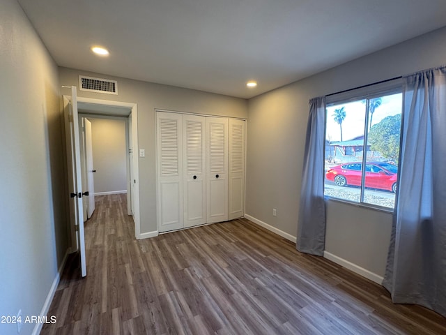 unfurnished bedroom with hardwood / wood-style flooring and a closet