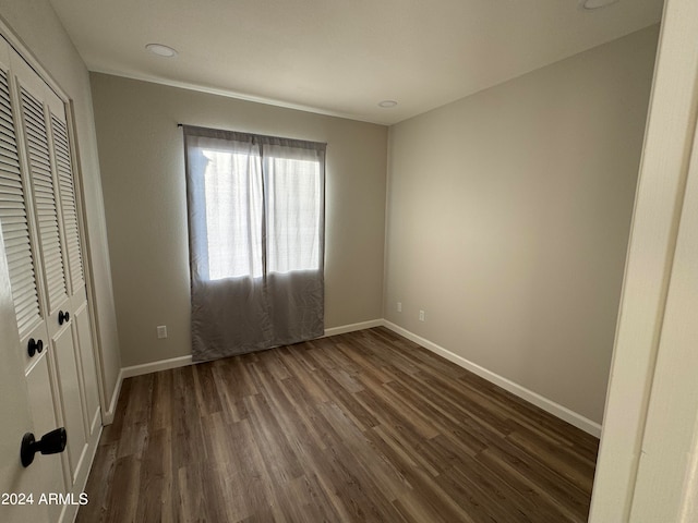 unfurnished bedroom featuring dark wood-type flooring and a closet