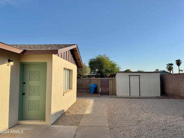 view of side of home with a storage shed